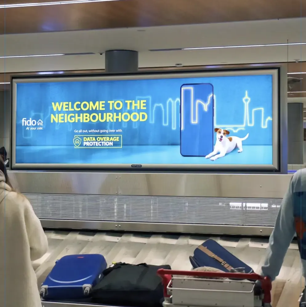 Pattison backlit digital display above an airport baggage carousel