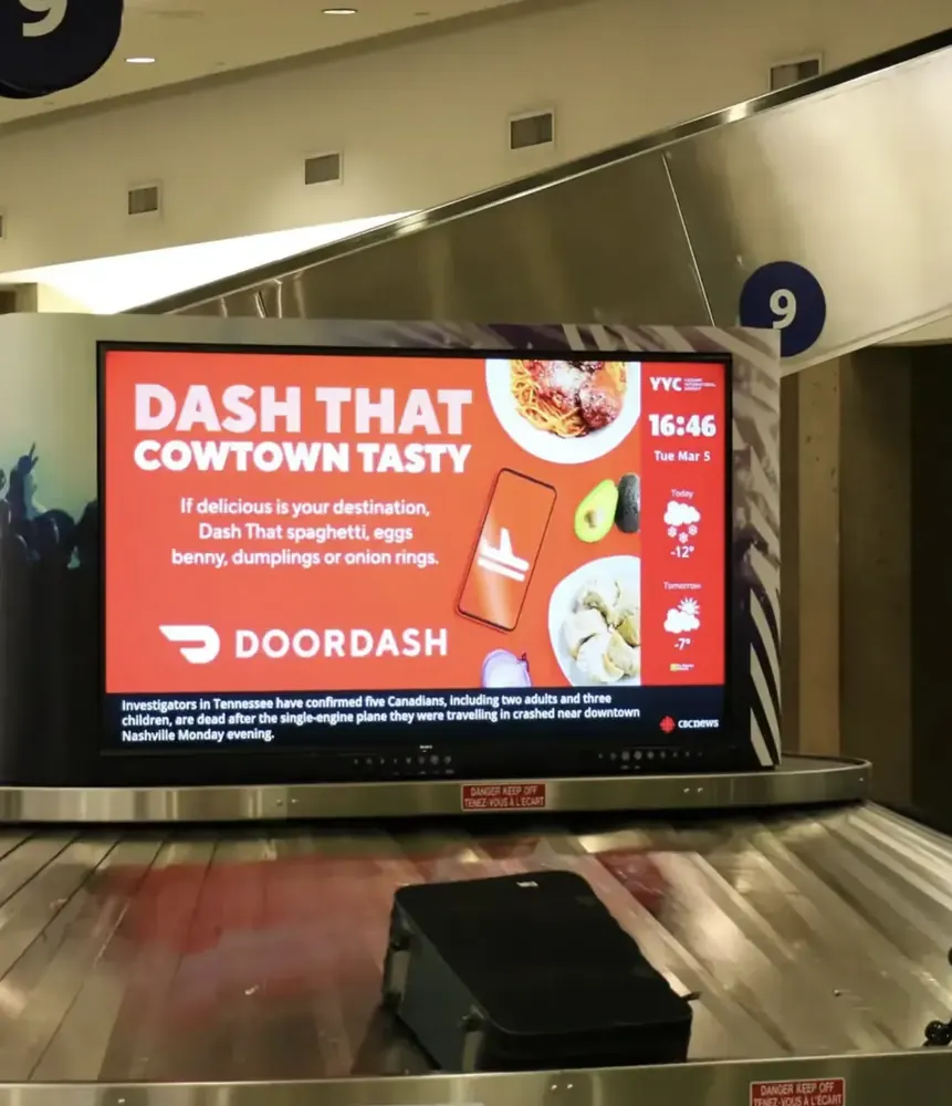 Pattison digital screen at a baggage carousel, Calgary International Airport