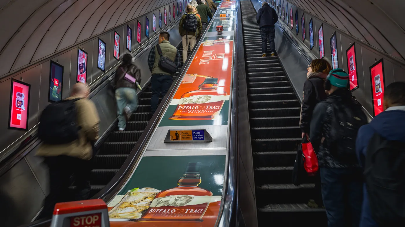 Digital escalator panels lining an Underground escalator